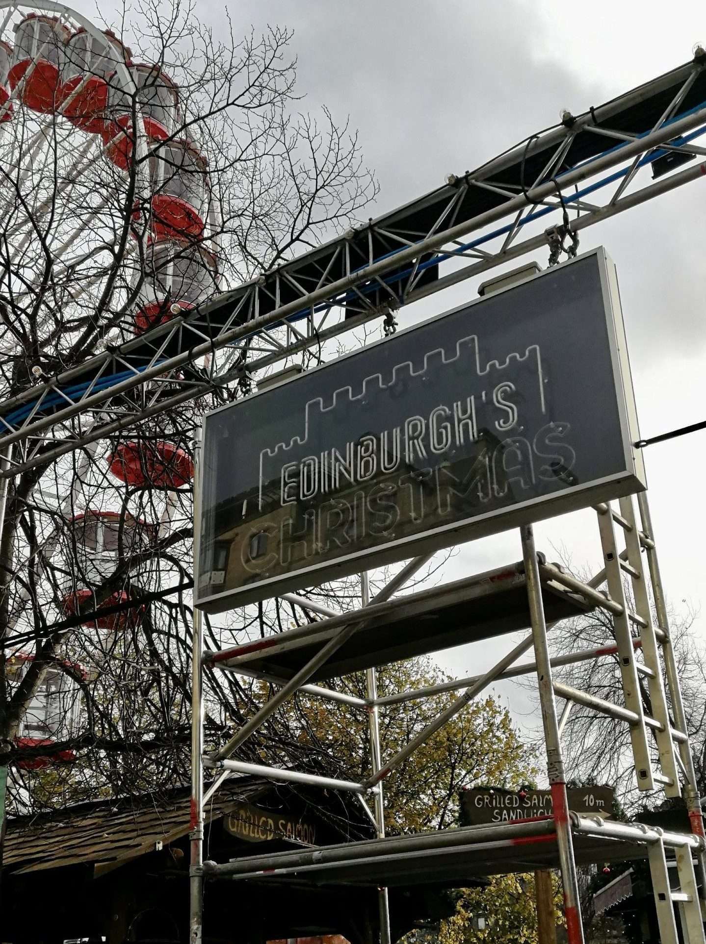 Entrata dei mercatini di Natale con scritta Edinburgh's Christmas e una parte della ruota panoramica nello sfondo