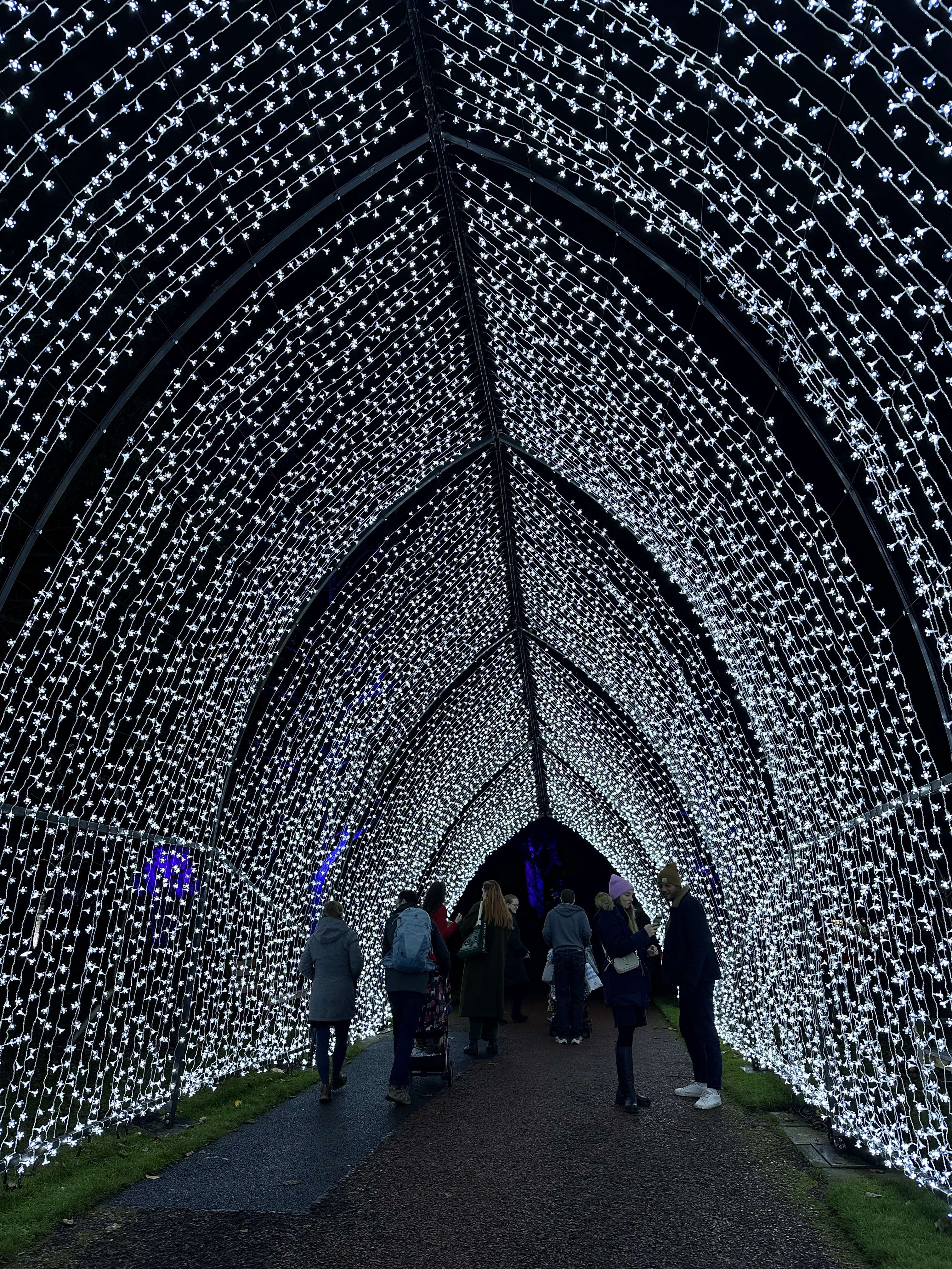 Tunnel illuminato creato da luci bianche con persone sullo sfondo