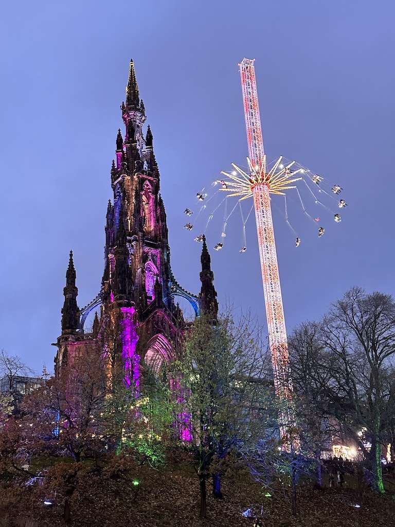 Cespugli con monumento Scott illuminato e giostra star flyer