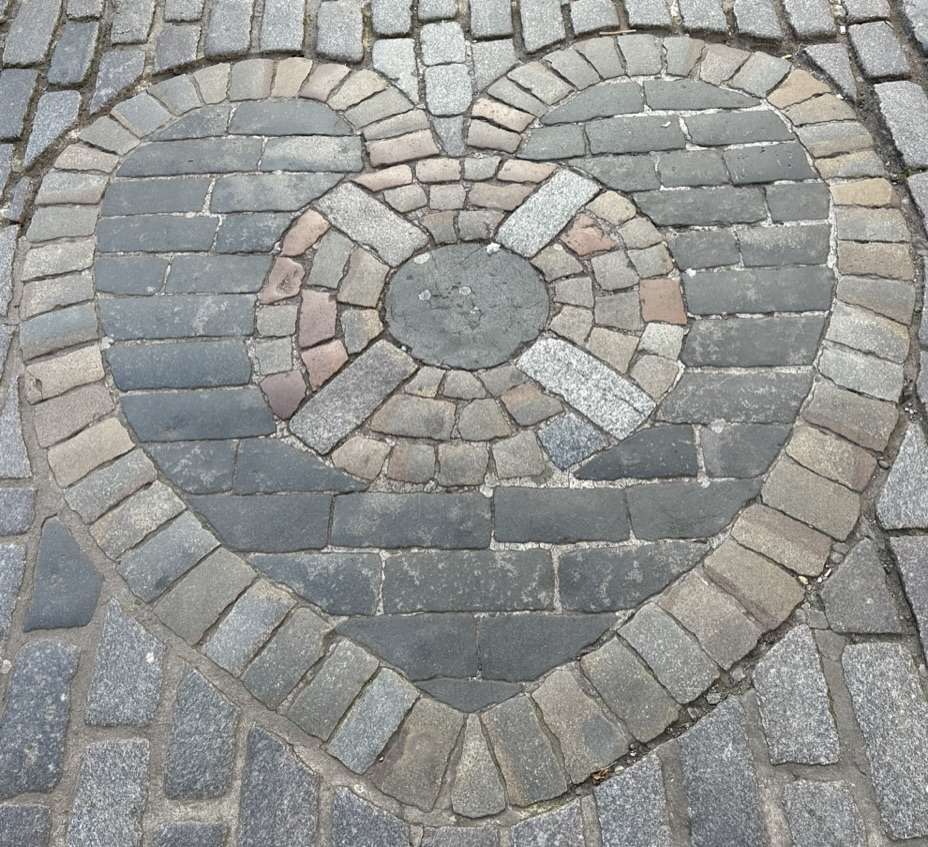 Mosaico a forma di cuore su pavimento strada