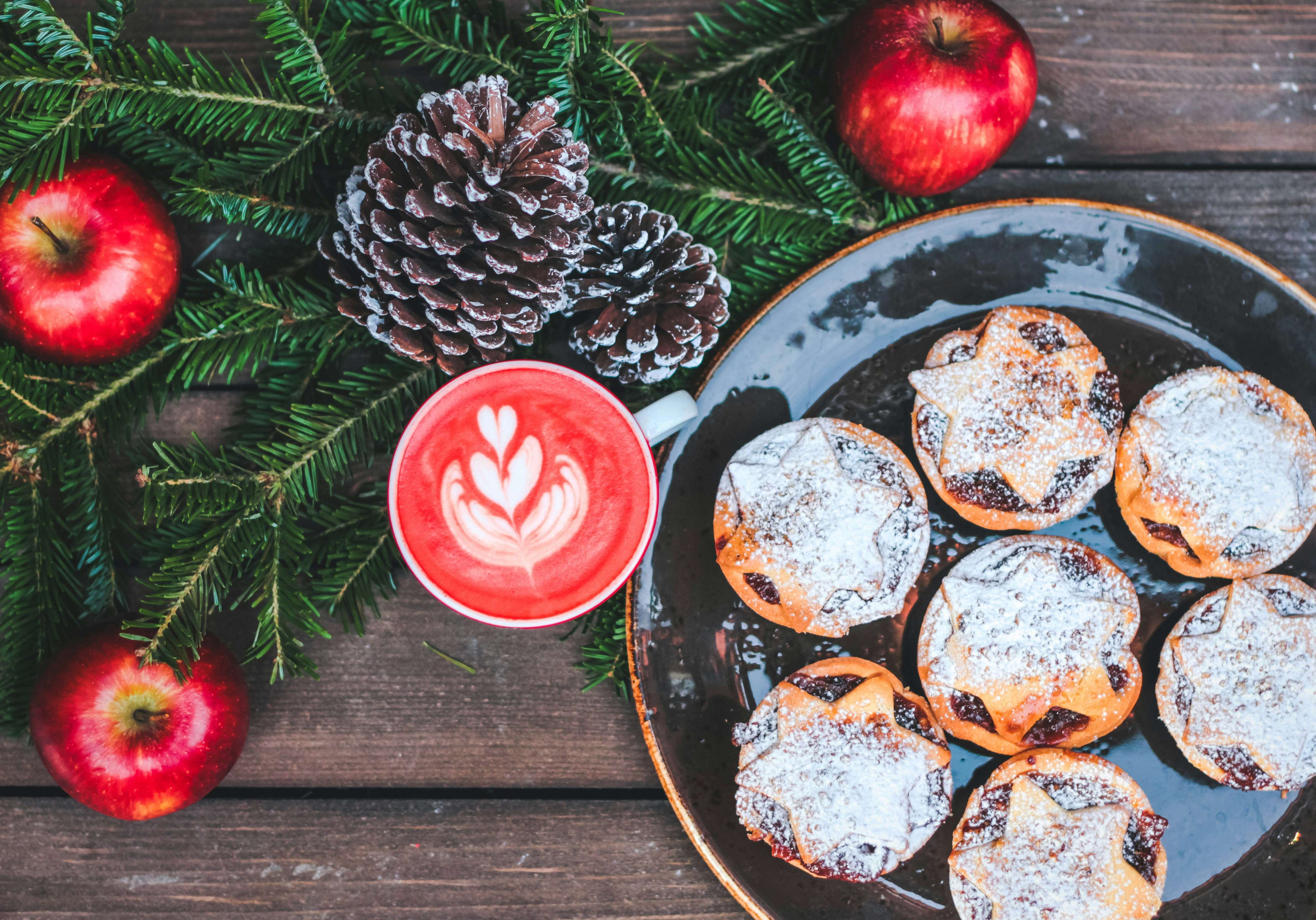 Tavola con mince pies tazza pigne e mele rosse