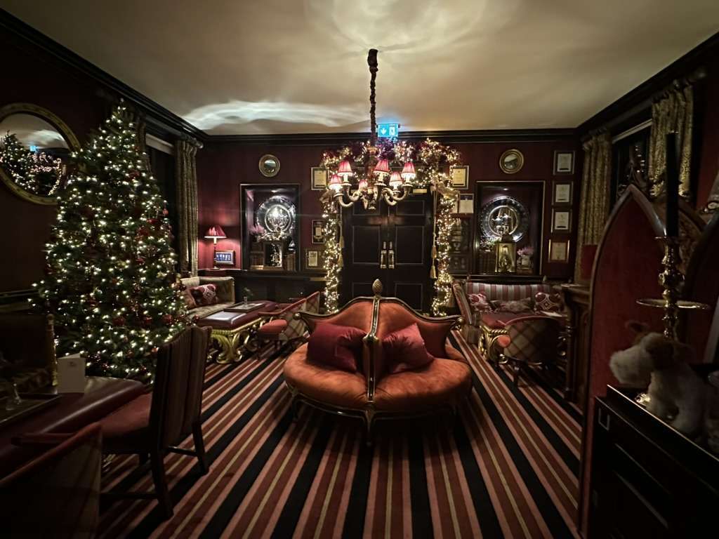 Sala con moquette rossa, divano rosso e albero di Natale illuminato