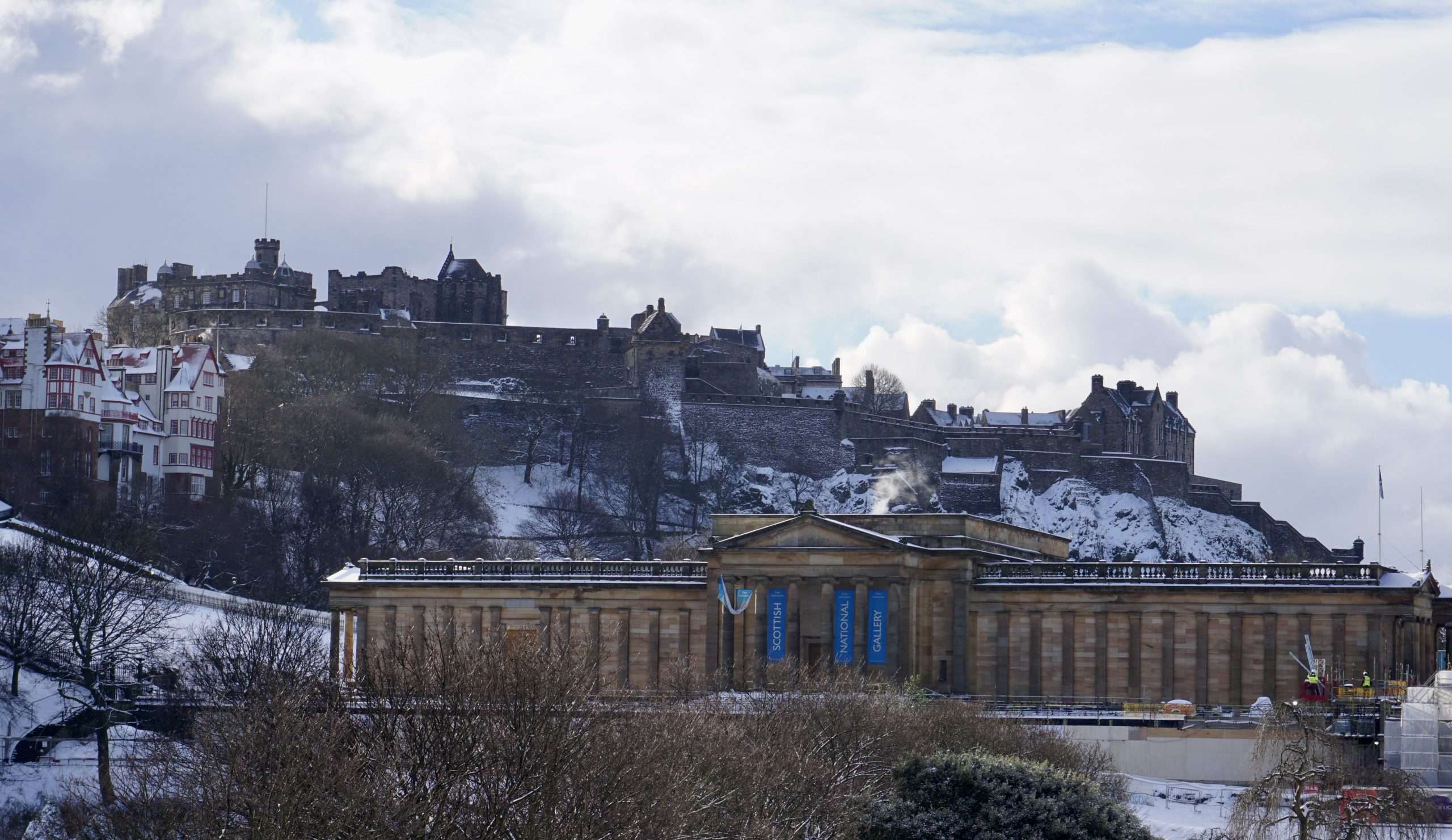 Castello di Edimburgo innevato con sotto l'edificio della National Gallery of Edinburgh