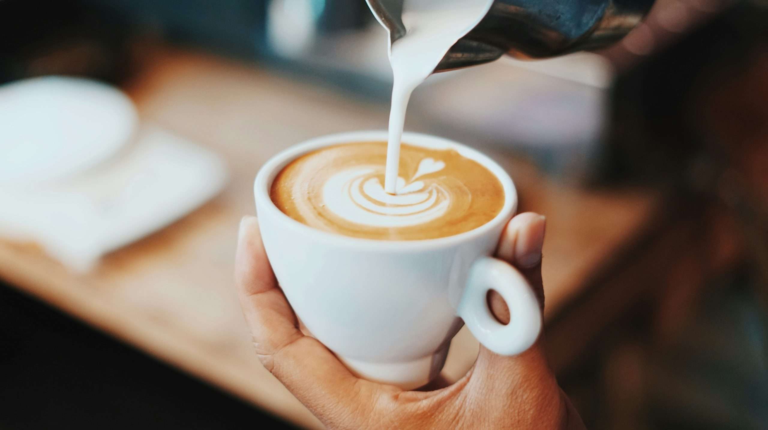 tazza di caffè mentre viene versato il latte