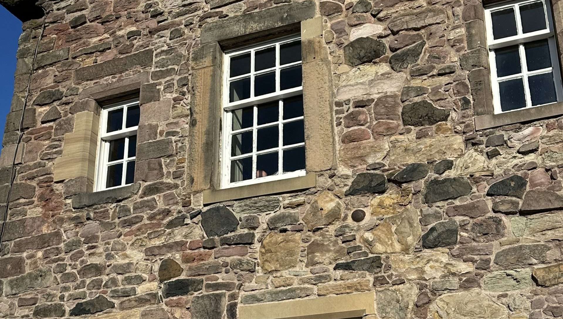 edificio di pietra con palla di cannone incastrata, cannonballs