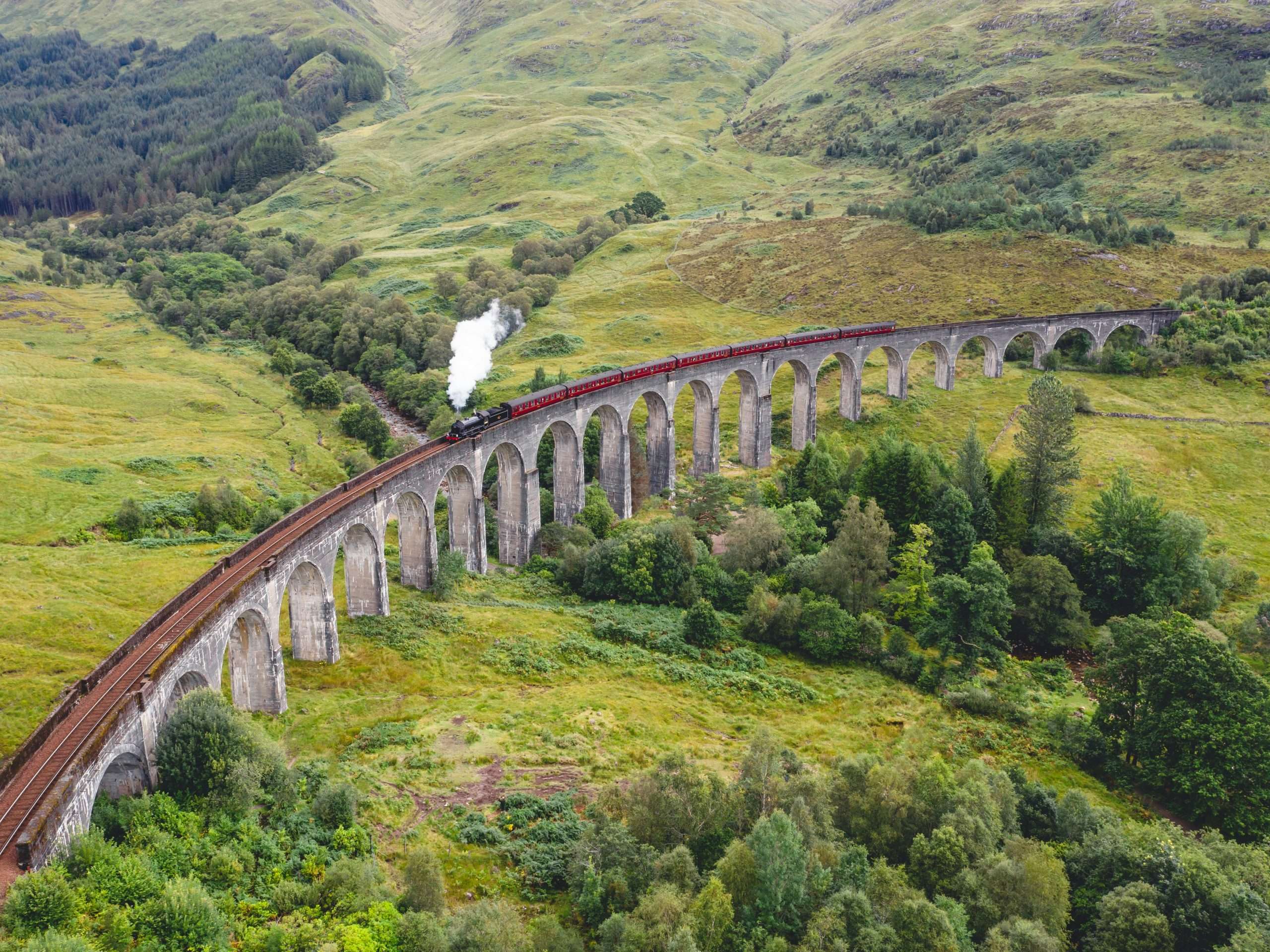 Glenfinnan, ponte ferroviario a 21 arcate con treno di Harry Potter sopra in Scozia