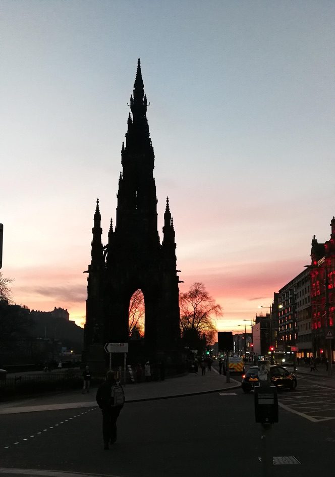 scott monument con il tramonto dietro e gente per strada a Edimburgo