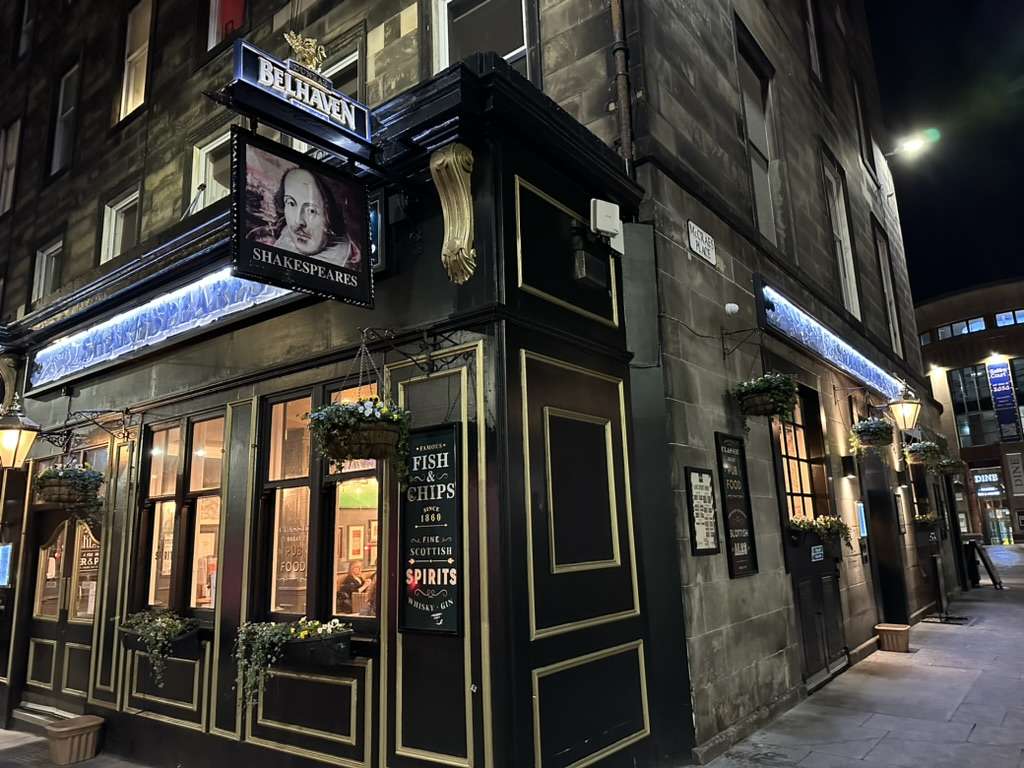 Esterno a Edimburgo di un pub con insegna e volto di Shakespeare