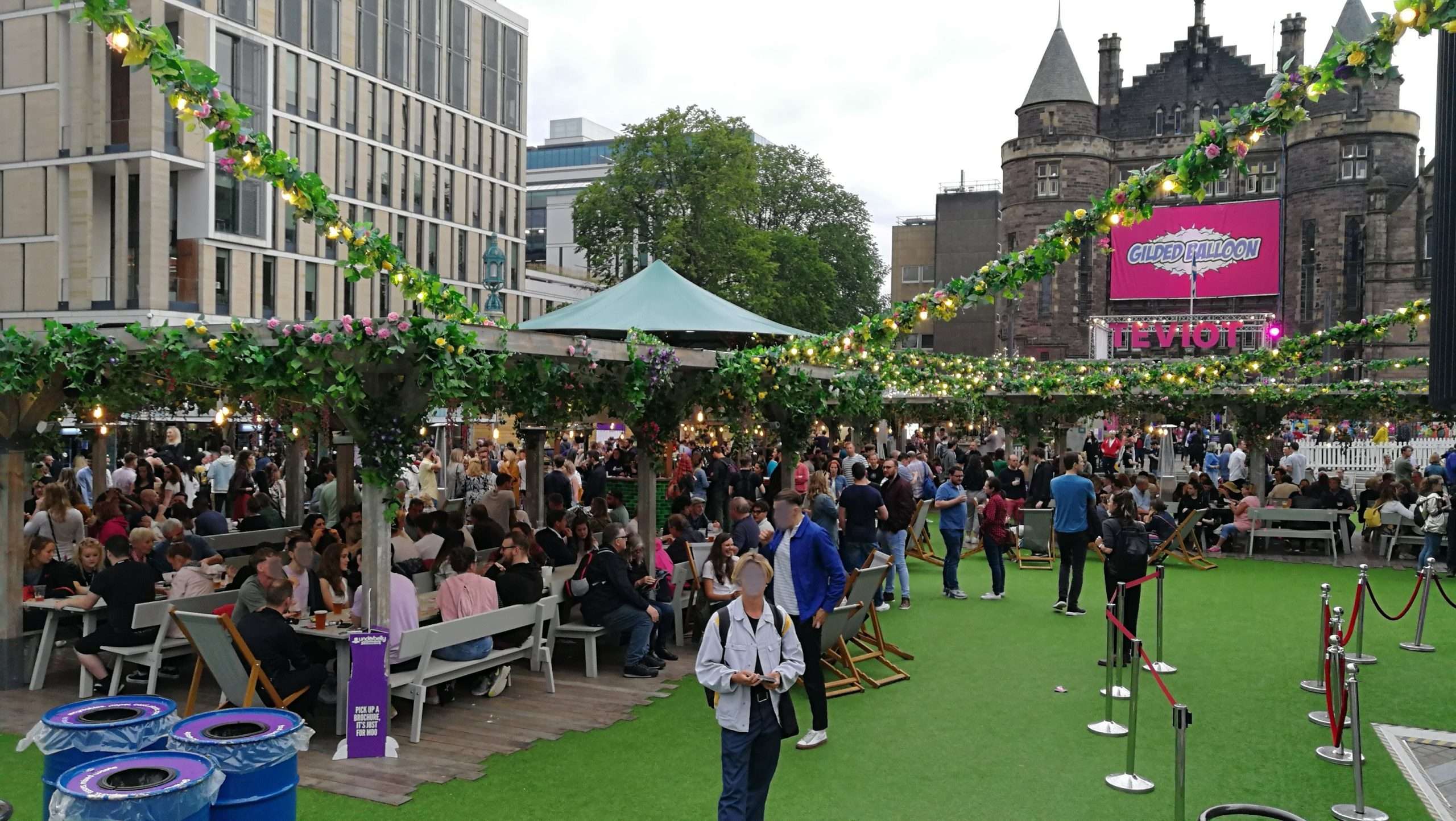 Prato con gente, gazepo, luci e panche al festival di Edimburgo