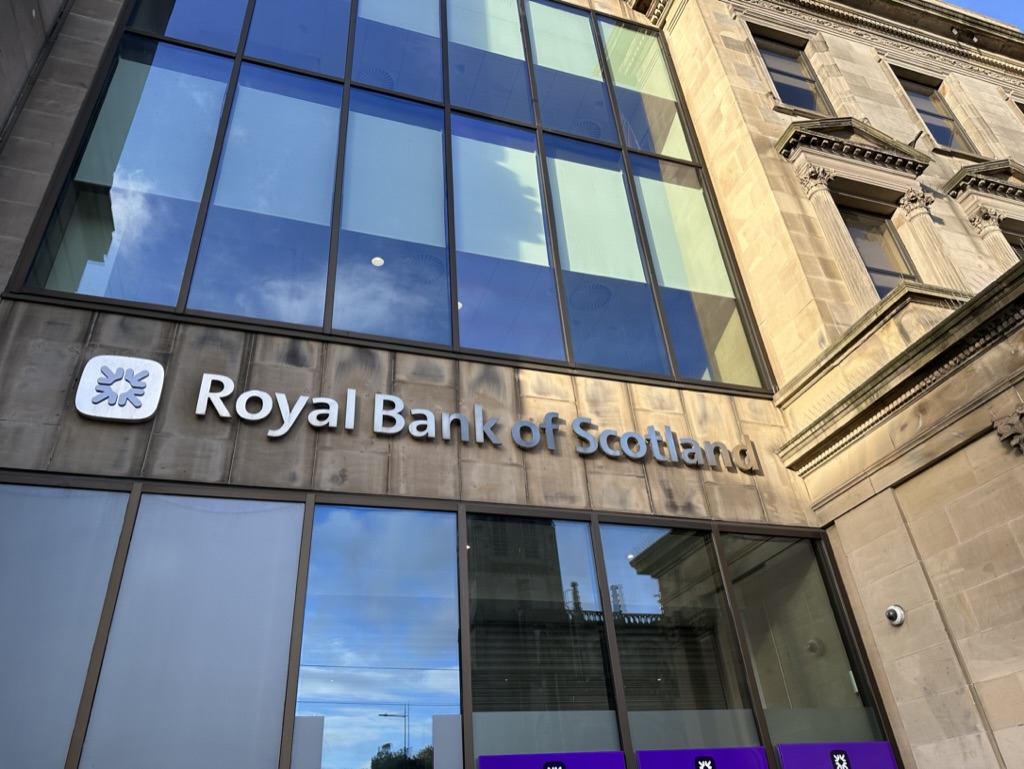 Primo piano dell'insegna Royal Bank of Scotland su un edificio moderno a Edimburgo, ideale per chi cerca lavoro nel settore finanziario.