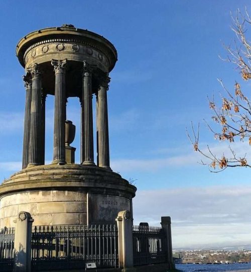 Monumento a Dugald Stewart sulla collina di Calton Hill, pavimento ricopero di neve e vista in fondo a destra della città