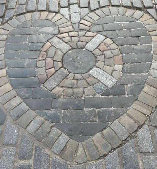 Mosaico a forma di cuore su pavimento strada